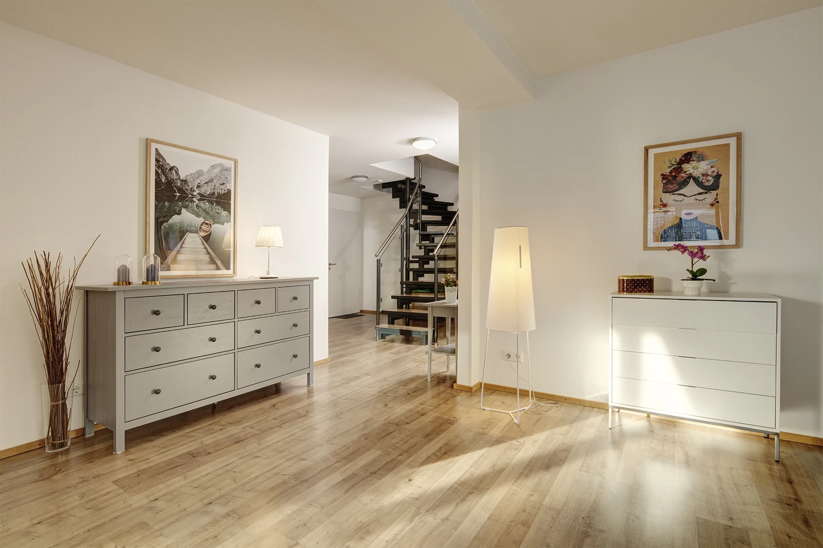 Blick auf zwei Kommoden und Treppe in heller Ferienwohnung Seestern