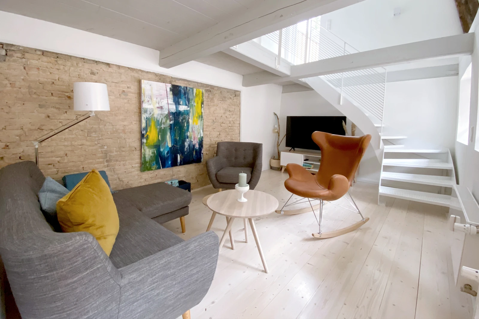 Design-Möbel und Treppenaufgang im Wohnzimmer des Ferienhauses Große 73